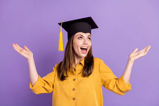 Portrait of her she attractive cheerful cheery dreamy girl wearing graduate cap celebrating win, having fun isolated on bright vivid shine vibrant lilac violet color background
