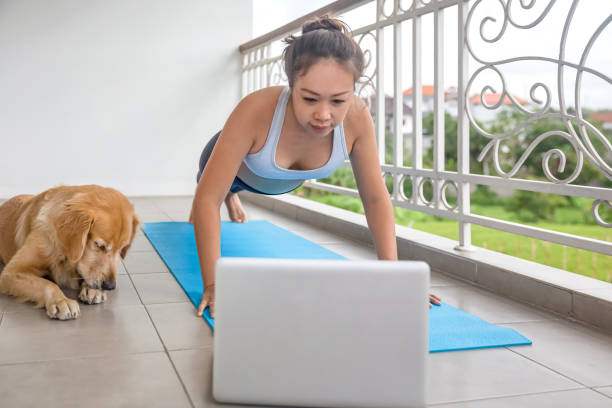 istock Asian woman following a plank workout from tutorial video on laptop 1278598993