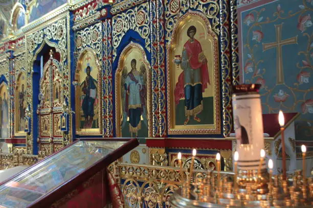 Krasnoyarsk, Russia, 05/19/2016 Illustrative Editorial A wall with icons in the church, gold trim, burning candles.