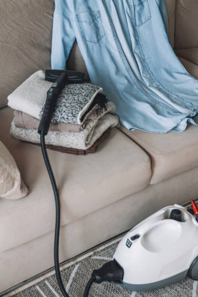 istock A stack of clean warm clothes and shirt with a steam cleaner on 1278600730