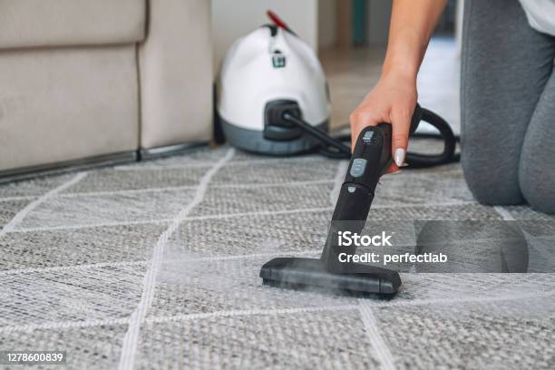 Woman Cleaning Carpet With A Steam Cleaner Stock Photo - Download Image Now - Carpet - Decor, Steam, Cleaning