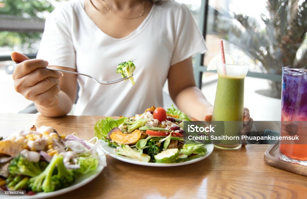 Selective focus of woman with Broccoli and salad which she make a Intermittent fasting with a Healthy food of salad and detox drink ,Healthy lifestyle Concept. Ketogenic Diet Stock Photo