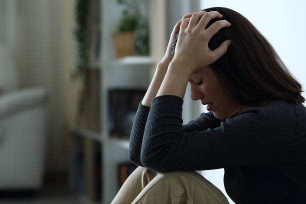istock Desperate sad woman complaining alone in the dark 1278602242