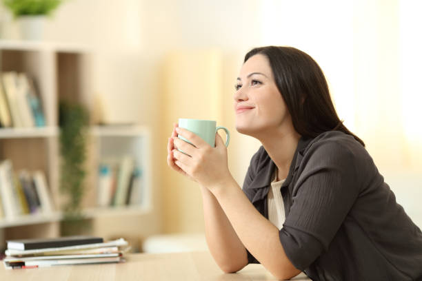 istock Woman dreaming and drinking coffee at home 1278602262