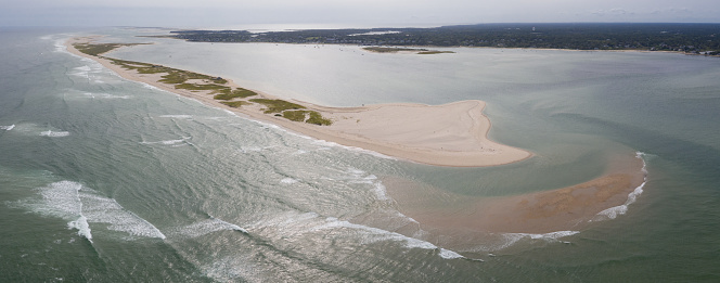 The cold water of the Atlantic Ocean washes onto the sandy beaches of Cape Cod, Massachusetts. This scenic peninsula is a popular summer vacation destination in New England.