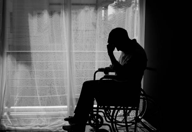 Silhouette of handicapped Man sitting on wheelchair in front of a large panoramic window in hospital,He is sad and lonely-Black and white tone Silhouette of handicapped Man sitting on wheelchair in front of a large panoramic window in hospital,He is sad and lonely-Black and white tone schizophrenia photos stock pictures, royalty-free photos & images