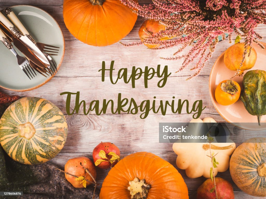 Thanksgiving dinner background with pumpkins Autumn thanksgiving wooden background with pumpkins, fall fruit and tableware for dinner. Greeting card with text Thanksgiving - Holiday Stock Photo
