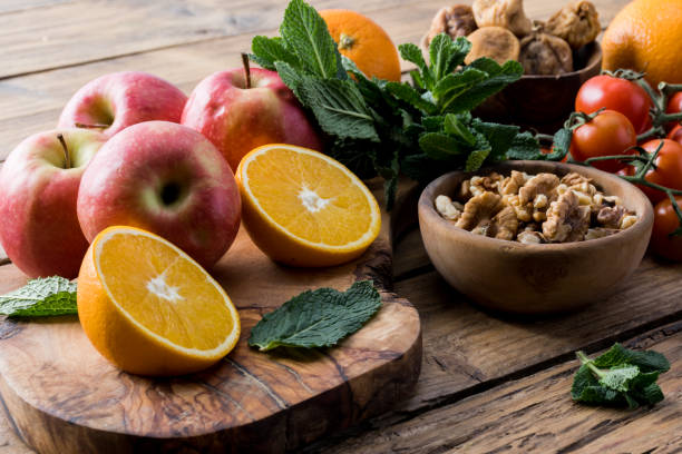 Colorful summer sweet salad with spinach, orange, cherry tomatoes, walnut, figs, quinoa, fresh fruit