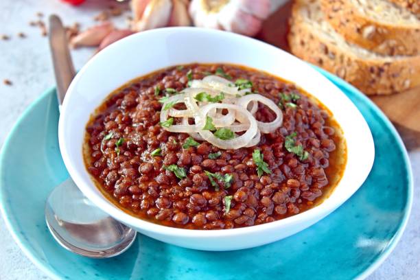 istock Lentils with stewed onion and tomato in a white bowl. 1278608824