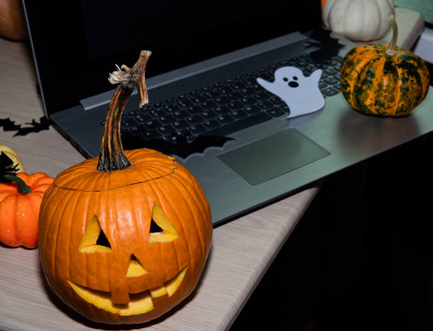 istock Pumpkin head, laptop, decorations for the Halloween celebration on the remote. 1278609927