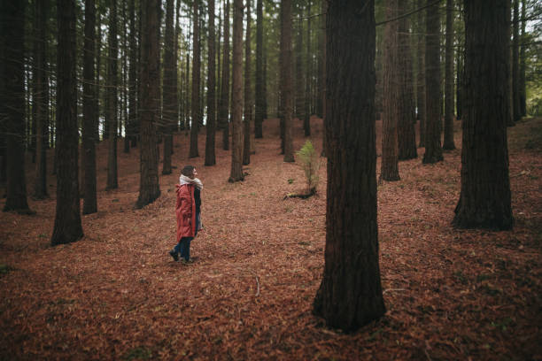 istock Young woman with raincoat at forest 1278616560