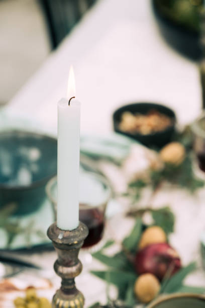 istock Candle burning on decorated table in Christmas setting. Close-up 1278617211