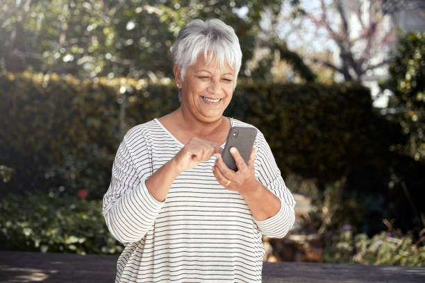 счастливая старшая женщина с помощью мобильного телефона - women telephone senior adult on the phone стоковые фото и изображения