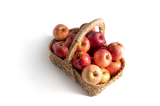Basket with fresh ripe apples standing on a table, fruit harvest in the summer, healthy organic food