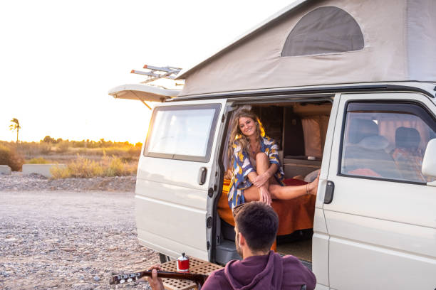 istock Couple with their camper van on a beach at sunset 1278626504