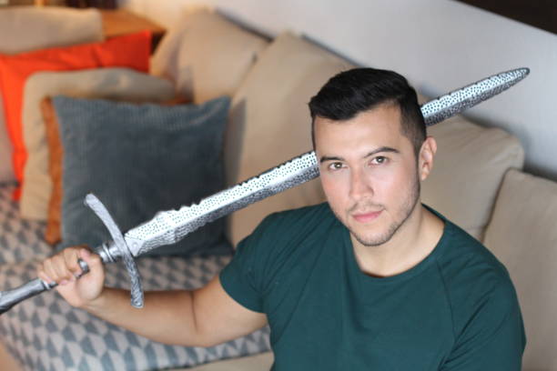 Geek holding a sword at home.