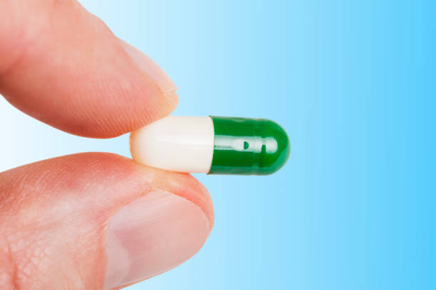 istock Fingers hold the capsule pill 1278628860