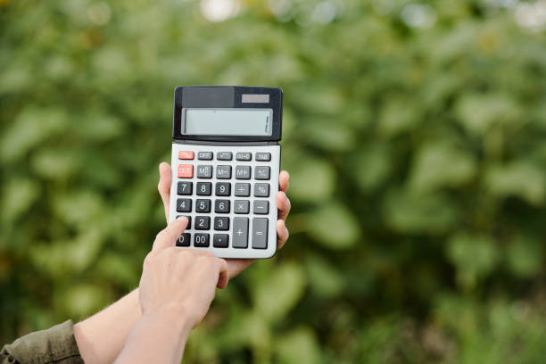 istock Hands of farmer holding calculator with one on its display and pushing button 1278630603