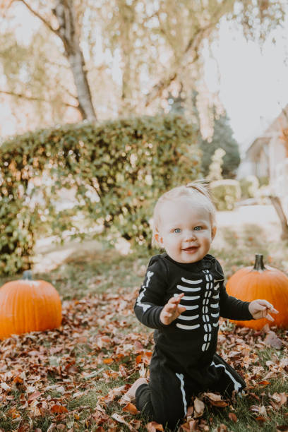 bambino che gioca fuori in costume di halloween - baby first steps autumn child foto e immagini stock