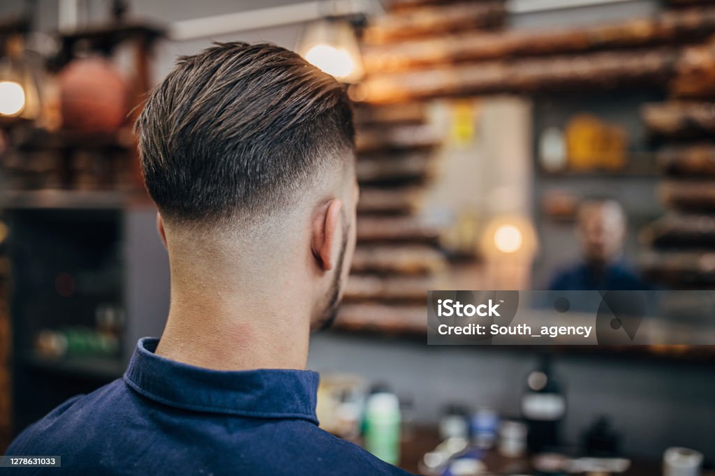 Handsome man with modern haircut One man, handsome young man with modern haircut at the barber shop. Men Stock Photo