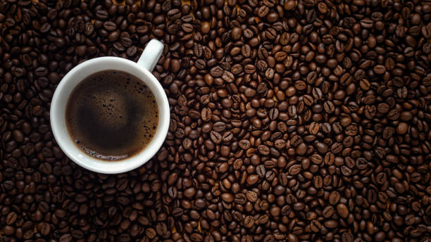 istock Flat lay of coffee cup on dark roasted arabica coffee beans background copy space 1278631843