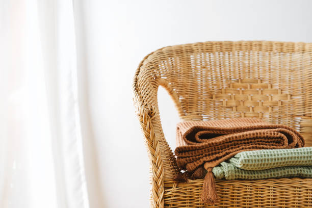 istock Wicker chair with trendy color blankets next to a white wall 1278631868