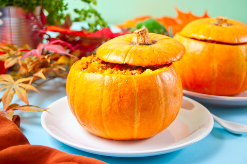 Fresh cooked pumpkin soup served in a pumpkin. Autumn warm and cozy food.