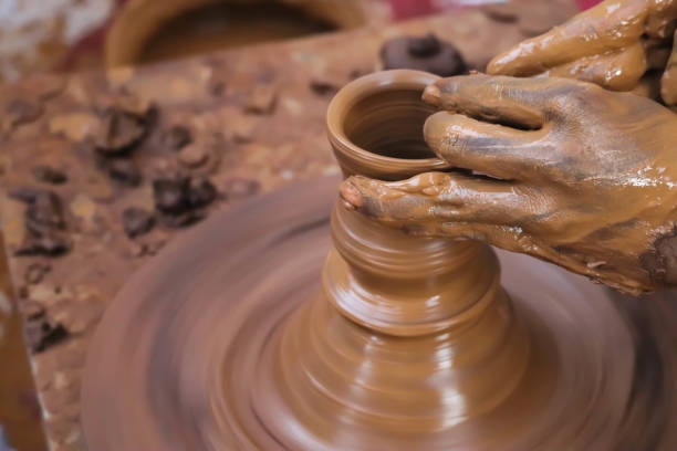 istock Dirty Hands Of Potter Making Pottery From Mud Using Spinning Potter Wheel 1278634104