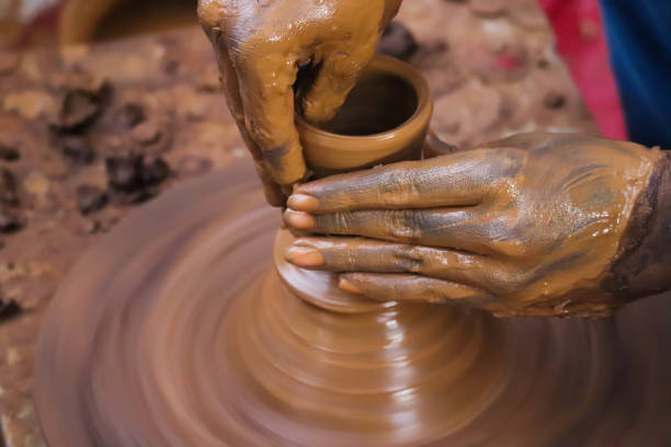 istock Hands And Fingers Posture Of Potter Making Pottery From Mud Using Spinning Potter Wheel 1278634144