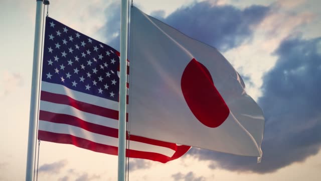 United states and Japan flags on a flagpole depict trade agreements and negotiations.