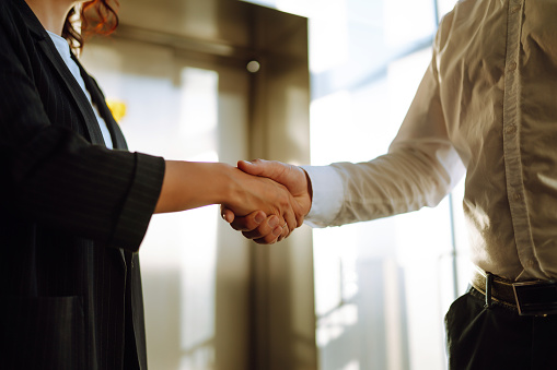 Close Up of business people shaking hands after contract meeting at customer office. Business etiquette, congratulation, merger and acquisition concepts.