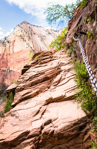 A chain handrail at the side of a steep footpath in the rock at Zion National Park in southern Utah.