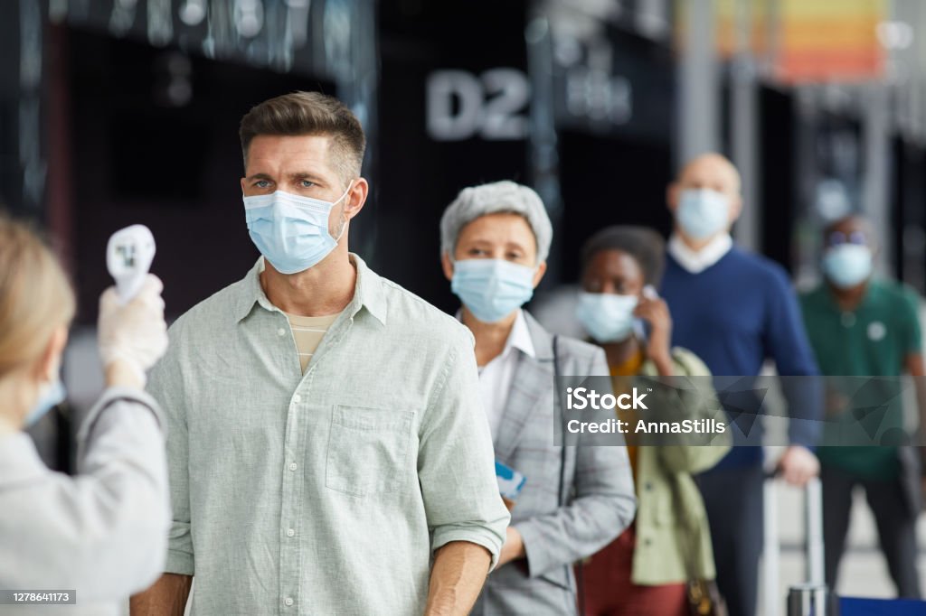 People in masks during pandemic Group of people in protective masks are being tested standing on the street outdoors Protective Face Mask Stock Photo