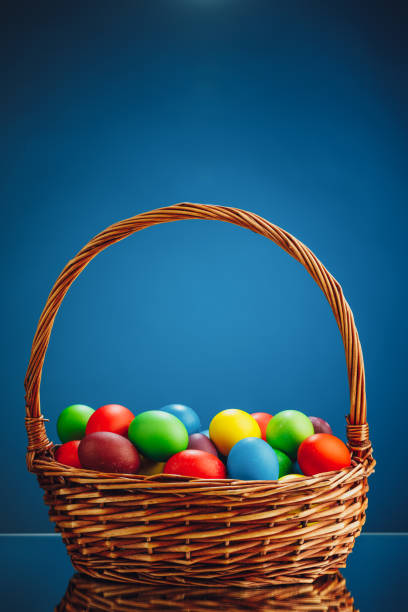 istock Easter color eggs in festive gift basket, blue background 1278641687