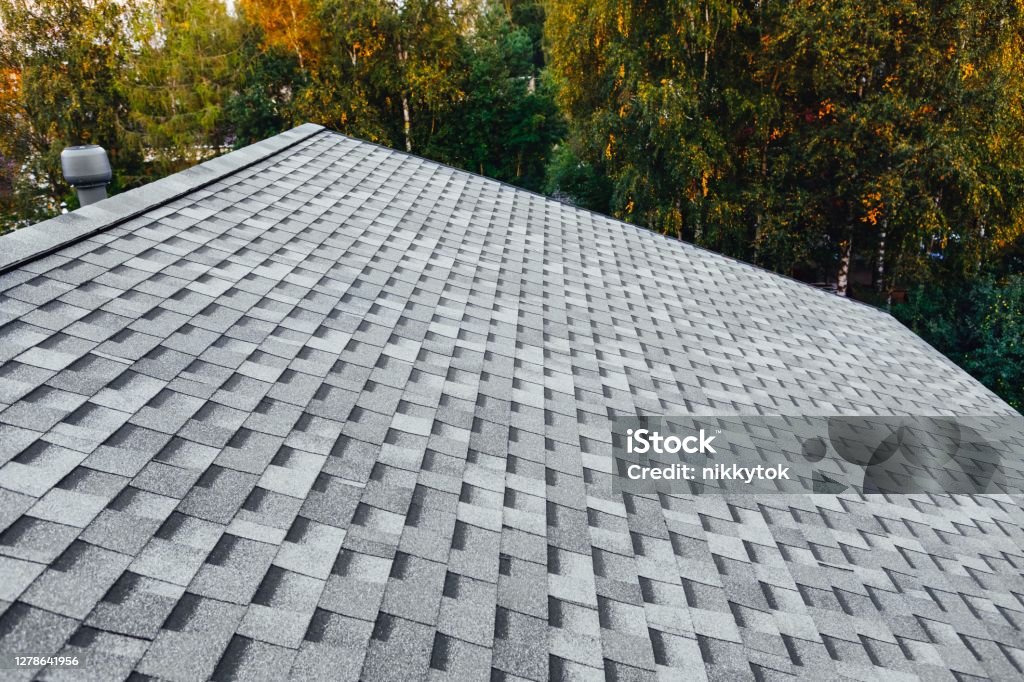 new renovated roof with shingles flat polymeric roof-tiles Rooftop Stock Photo