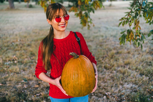 istock Woman holding an orange pumpkin 1278643147