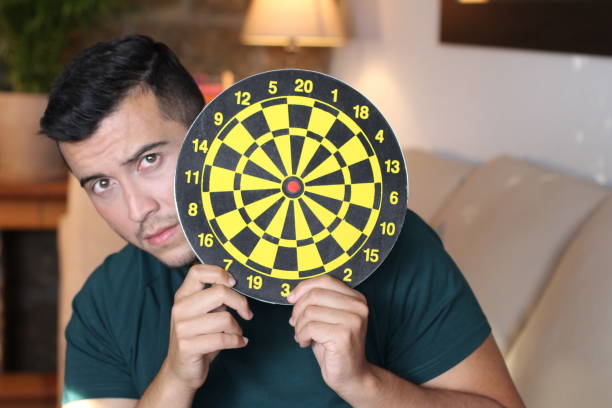 scared man holding bulls eye - target aspirations bulls eye dart imagens e fotografias de stock