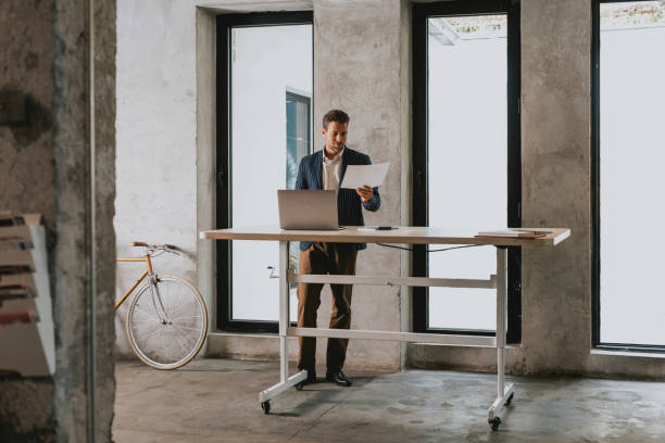istock Businessman in a Suit Working at a Standing Desk 1278645131