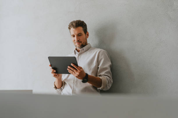 Handsome Caucasian Businessman Reading Something on his Tablet at Work (Copy Space)