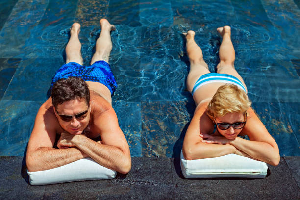 istock Retired seniors couple relaxing in swimming pool 1278647724