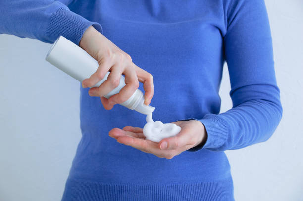 istock Caucasian woman blue sweatshirt squeezes styling foam into her hand. 1278648073