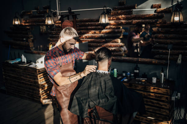 istock One handsome hairstylist using scissors and comb 1278648131