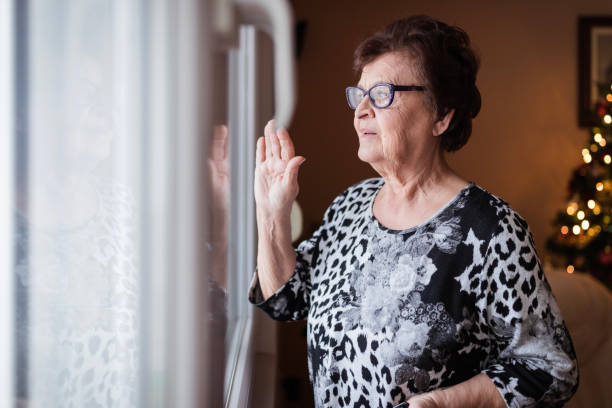 istock Senior woman looking through the window 1278648406