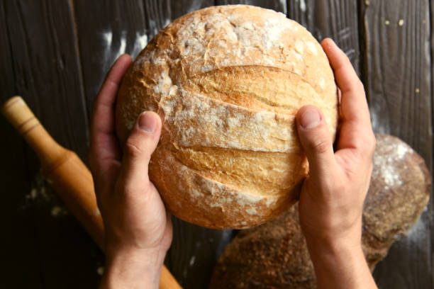 istock Men hands hold round fresh baked bread 1278651580