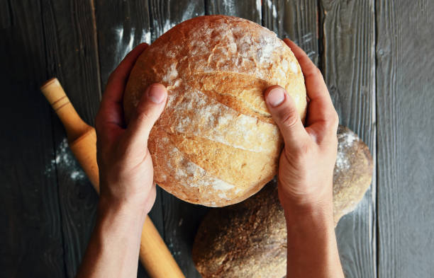 istock Chef is holding the bread in his hand above the kitchen table. 1278651683