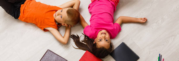 istock Kids reading for school lying on floor at home 1278653549