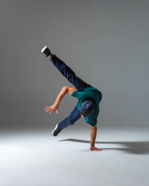 istock Cool b-boy dancing on one hand in studio isolated on gray background. Breakdance poster 1278653591