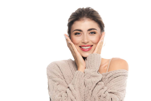 istock joyful woman in openwork sweater touching face while looking at camera isolated on white 1278653659