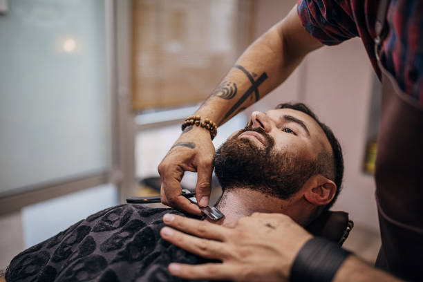 istock Close up of a barber with old-fashioned razor shaving client´s beard 1278655035
