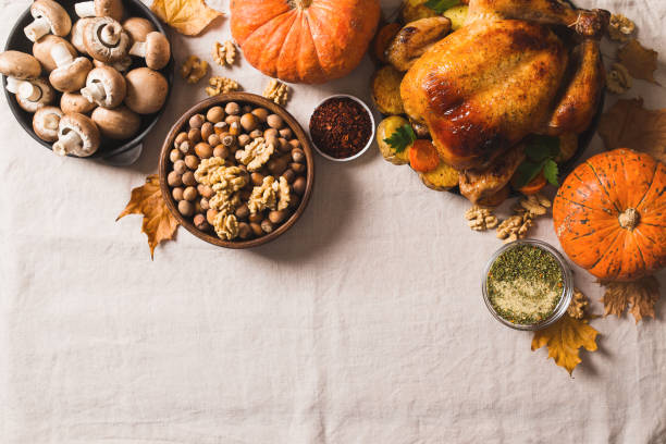 istock Fall thanksgiving table with roasting chicken or turkey, nuts, pie, pumkins and other food on light 1278655426
